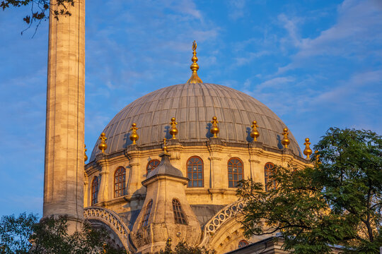 Close-up of a mosque dome and minaret with gilded accents at sunset in Istanbul
