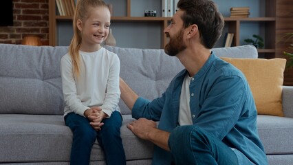 Happy Caucasian family at home dad talking with cute daughter positive glad smiling together father...