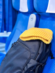 Travel Essentials on a Train Seat &ndash; Backpack and Beanie