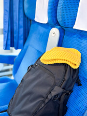 Travel Essentials on a Train Seat &ndash; Backpack and Beanie.