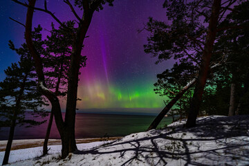 Northern lights on a full moon night overlooking the sea