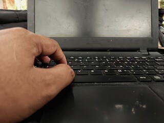 Hand typing on laptop keyboard