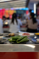 Fresh Leafy Greens on Plate at Shabu-Shabu Conveyor Belt Restaurant
