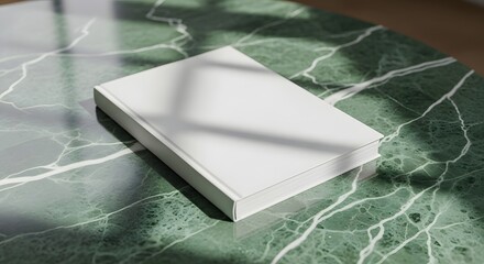 A blank book cover mockup displayed on a green marble stone coffee table with soft shadow overlays, creating a modern and elegant scene ideal for branding or editorial presentation visuals