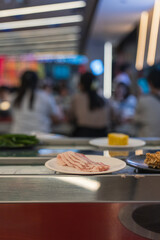 Pork Belly Slices on Plate at Shabu-Shabu Conveyor Belt Restaurant