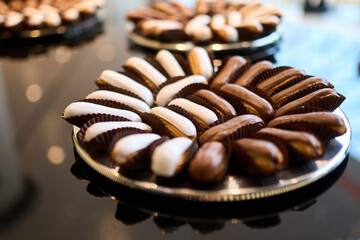 Assorted Mini Éclairs with Chocolate and Vanilla Glaze on Silver Tray