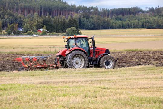 Farmer Working in Field with Case IH Puma Tractor and Agrolux Plough on a Day of Autumn.