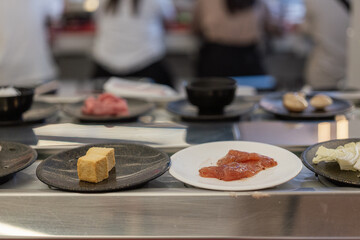 Tofu and Raw Meat Slices Side by Side at Shabu-Shabu Conveyor Belt Restaurant