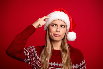 Funny santa hat moment as a young woman in a red sweater ponders christmas shopping and winter cheer for the holiday season
