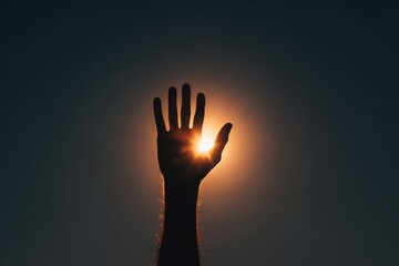 Silhouette of a hand reaching toward a glowing light, symbolizing ambition, hope, and aspiration.