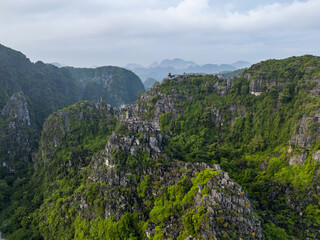 Aerial view of verdant limestone karsts rise majestically from the landscape, cloaked in emerald foliage, Hang MÃºa, Hoa LÆ°, Ninh BÃ¬nh, Vietnam.