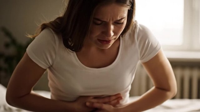 Gripping pain A woman clutches stomach