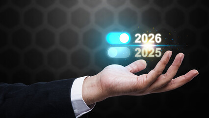 Business hand showing the year 2026 above 2025 on a virtual screen. Happy New Year concept or Celebration