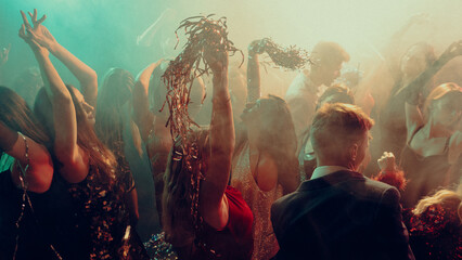 Christmas crowd dancing under warm haze and golden festive light. Concept of holiday branding,...