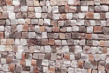 The background of the fragment is a Roman mosaic made of small cubic pieces of tesserae in soft beige, white and delicate pink shades