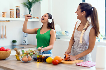 Beautiful mother and daugther having a good time while cooking in the kitchen