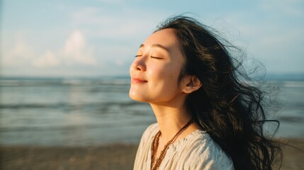 Obraz premium Feeling the gentle breeze a woman closes her eyes by the ocean experiencing tranquility and joy.