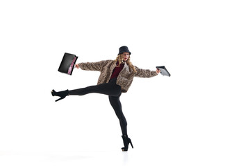 Stylish woman in leopard print jacket posing with shopping bags in dynamic expressive motion. Concept of power dressing, individuality, creativity, and confident emotion in modern retail fashion.