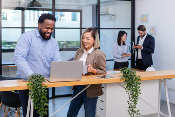 team of multiethnic colleague discuss business topic in creative green office co working space, group of business people coworker casual online meeting on laptop standing desk modern office workplace