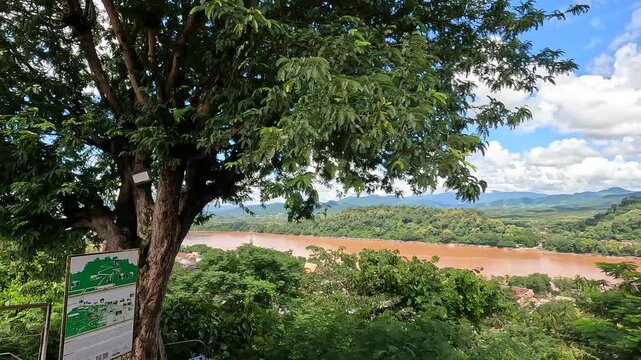 Aerial view from Mount Phousi overlooking Luang Prabang, northen Laos - spring day with sunshine and clouds over the Mekong River and city landscape.