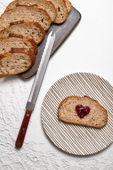 Close up of Artisan Sourdough Bread and Heart-Shaped Jam Toast on White Background