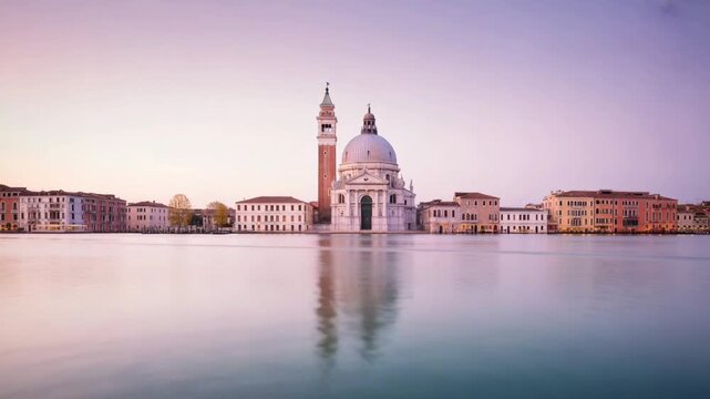 Venice cityscape with santa maria della salute church and grand canal at sunrise with calm water reflection