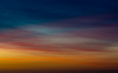 Vibrant layers of colour in the sky at sunrise with soft cloud textures