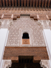 Intricate Plaster and Carved Wood Details of a Historic Moroccan Building Facade in Marrakech, Showcasing Islamic Geometric Patterns
