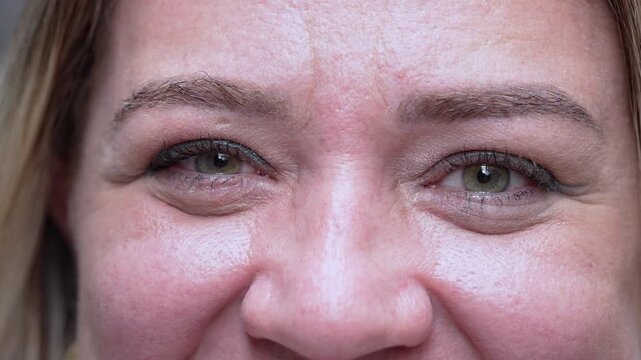 Extreme Close Up Of Green Eyes And Upper Face Of Woman Smiling, Detailed Facial Texture And Laugh Lines Visible During Joyful Moment