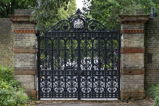 Forged iron gate with decorative details in a brick wall, Royal Botanic Gardens (Kew Gardens), UNESCO World Heritage Site, Kew, Greater London, England, United Kingdom