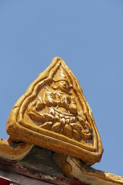 Roof decoration on the Uposatha Hall, Ubosot, the roof is staggered in three tiers and covered with rows of golden yellow glazed Chinese tiles, the last tile of each row at the eaves represents a heavenly angel offering the traditional Thai obeisance Wai to the viewer with folded hands, Wat Benchamabophit, marble temple, Bangkok, Thailand