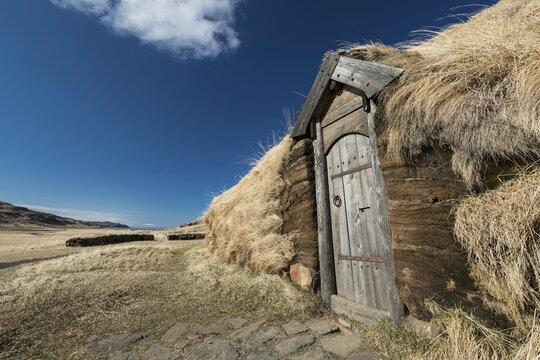 Traditional turf house with wooden door and grass roof in the sunshine, replica of a Viking longhouse, home of Eir&iacute;kr &THORN;orvaldsson or Erik the Red, Eir&iacute;kssta&eth;ir, Iceland