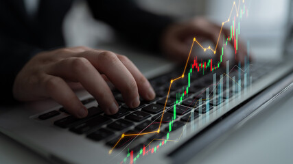 A professional individual works on a laptop surrounded by financial graphs, symbolizing stock...