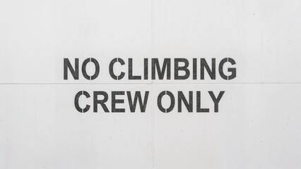 No Climbing Crew Only stenciled on white wall
