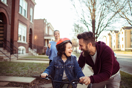 Young family enjoying bike ride in neighborhood