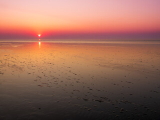 Expansive tidal flats at low tide off the coast of Friesland, Netherlands, sunset over Unesco Wadden Sea wetlands