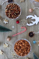 Various Christmas decorations, cookies, chocolate and nuts on wooden background. Flat lay.