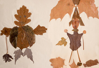 Childish crafts made from dried leaves. Two manikins
