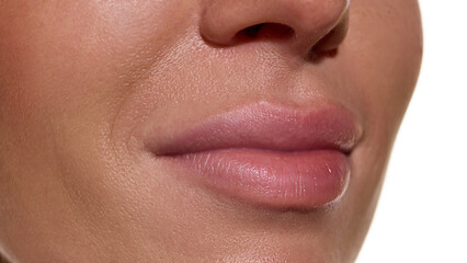 Lips close-up with smooth hydrated surface and soft natural tone. Concept of cosmetic surgery...