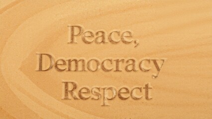 Wooden sign displaying the words peace, democracy, and respect