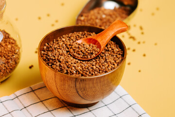 Buckwheat groats in a wooden bowl ready for cooking or serving in a warm kitchen setting