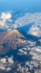 Majestic mount fuji peak peeking through fluffy clouds from above © Sorina