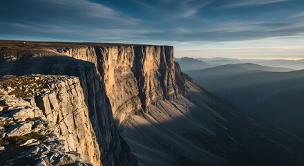 The sheer vertical drop of a mountain cliff.