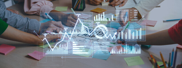 Team members engage in a collaborative project session, utilizing charts and graphs for business strategy, fostering creativity and productivity in a modern workspace. Scalp
