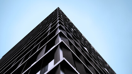 Minimalist architecture photographed from below with wide blue sky and generous copy space, expressing modern urban design and clarity.