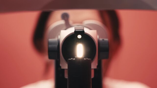 Patient undergoing vision examination with advanced ophthalmic equipment, bright light illuminating the eye, showcasing the importance of eye health and professional care in ophthalmology