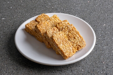 Crispy and tasty fried tempeh served on a white plate