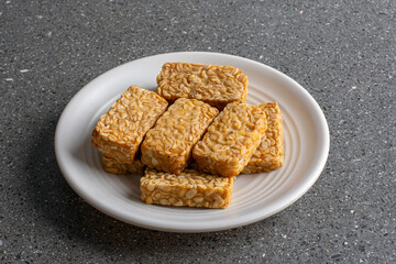 Crispy and tasty fried tempeh served on a white plate
