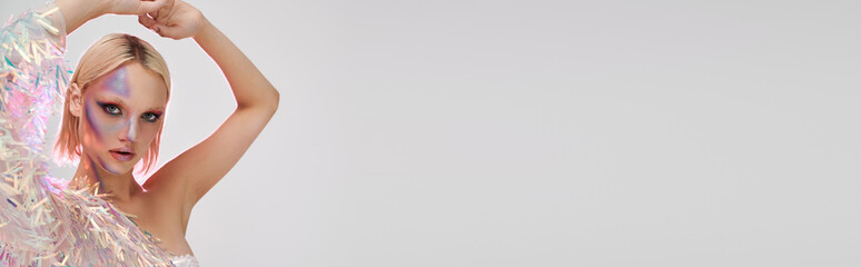 Young blonde woman poses confidently in a stylish party outfit with holographic accents