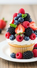 A close-up image of a cupcake brimming with vibrant, fresh berries. A vanilla frosting base holds raspberries, blueberries, blackberries, and strawberries